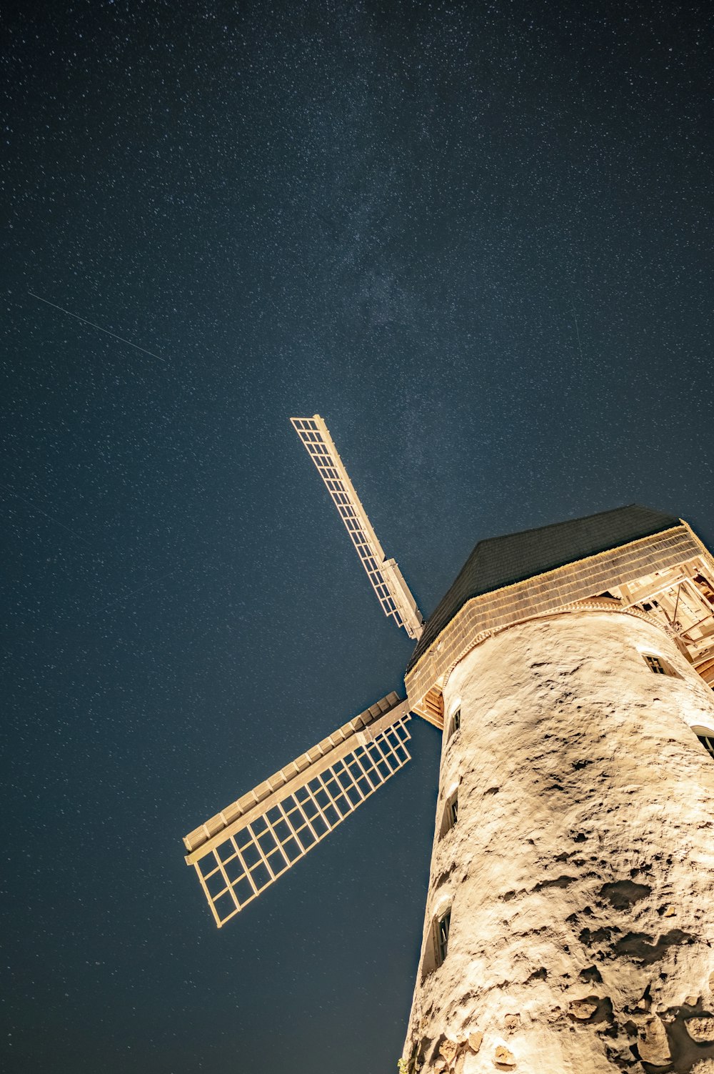 a windmill with a star filled sky in the background