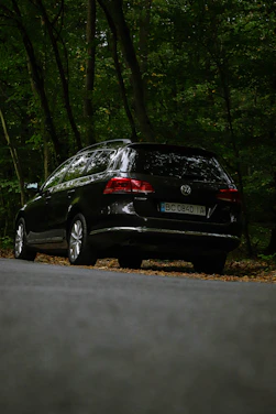 A sleek new Volkswagen Passat with Ardi Rental license plate parked by the seaside in Golem.