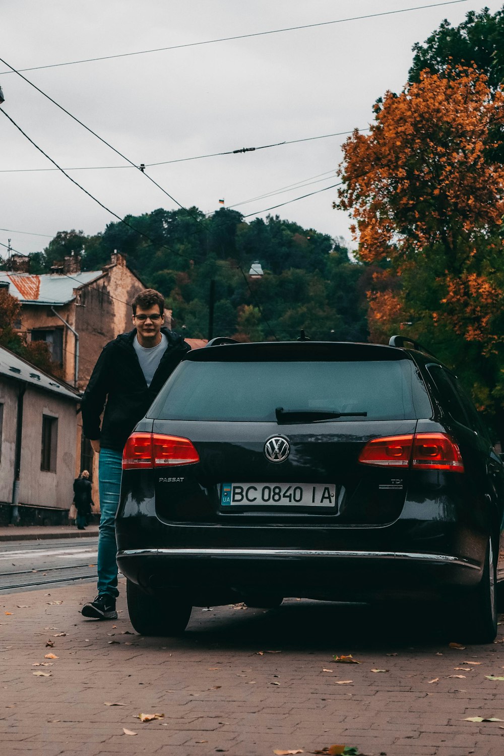 a man standing next to a black car