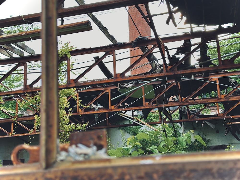 a rusted metal structure with a clock tower in the background