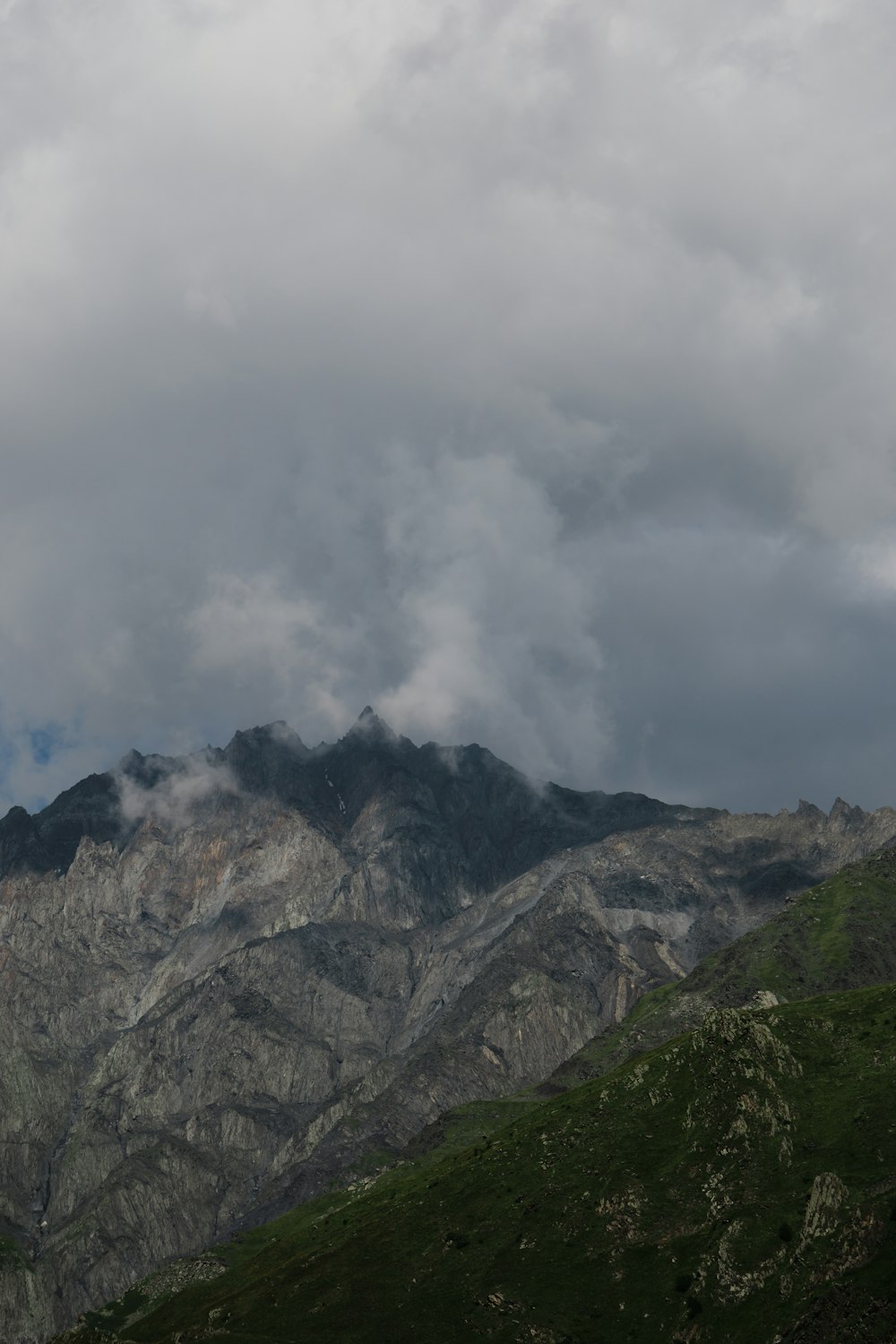 a mountain range with a few clouds in the sky