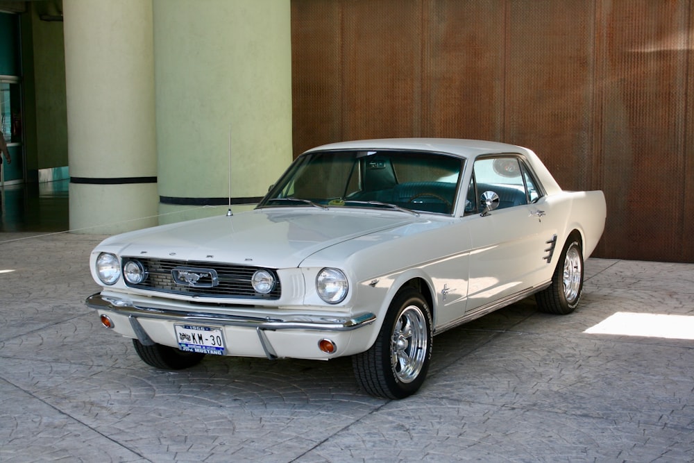 a white mustang parked in front of a building