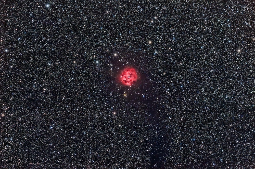 a red object in the middle of a black sky