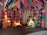 A rustic room decorated with colorful kites hanging from the ceiling and large, vibrant fabric lamps arranged in rows along the walls. A mannequin resembling a woman in traditional attire is sitting, while holding a child mannequin. A small painted alcove, resembling a candle or diya, adds to the room's cultural theme.