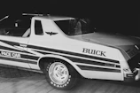 Historic black and white image of an Avis car team preparing for a race.