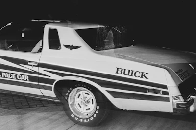Historic black and white image of an Avis car team preparing for a race.