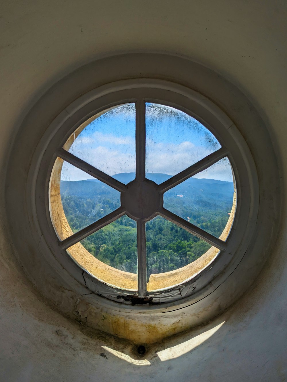 a round window with a view of a valley