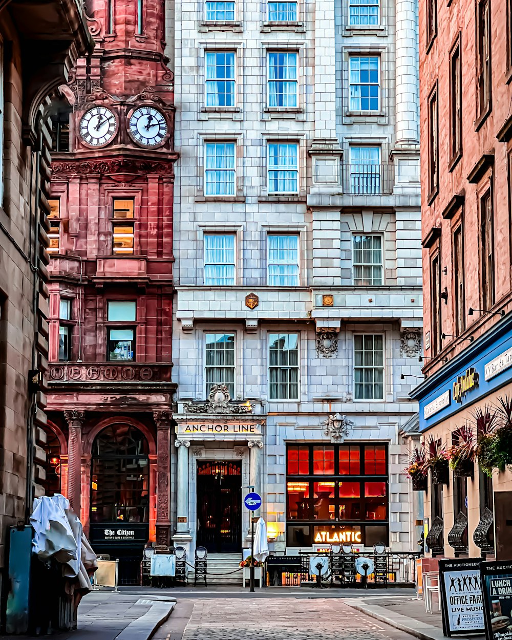 a city street with tall buildings and a clock tower