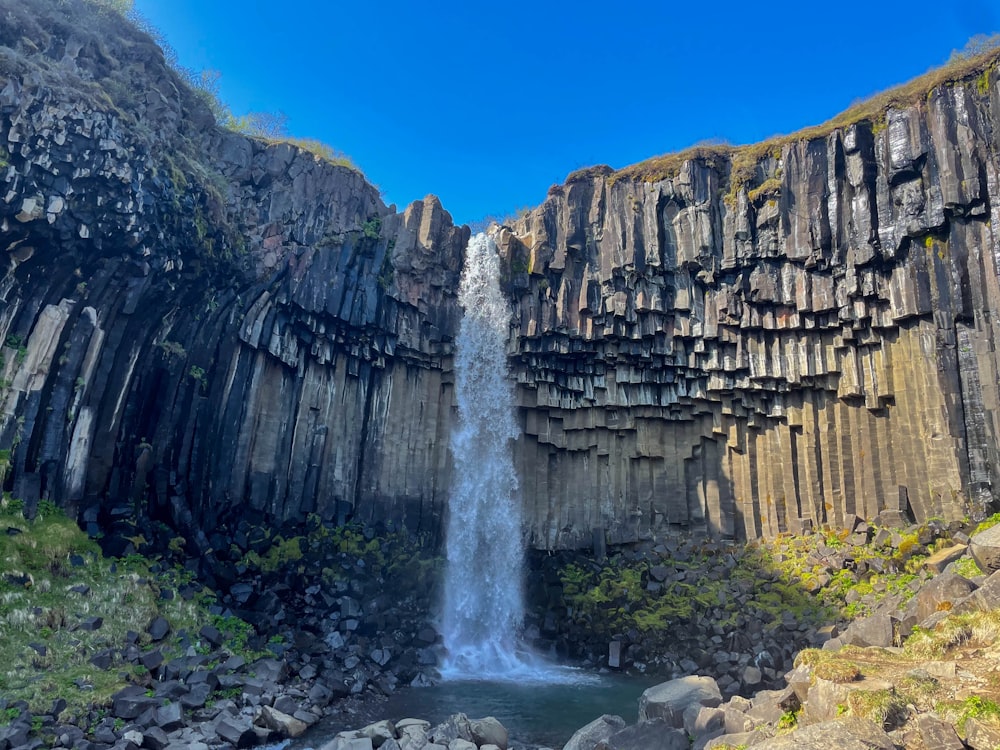 a waterfall is seen from the side of a cliff