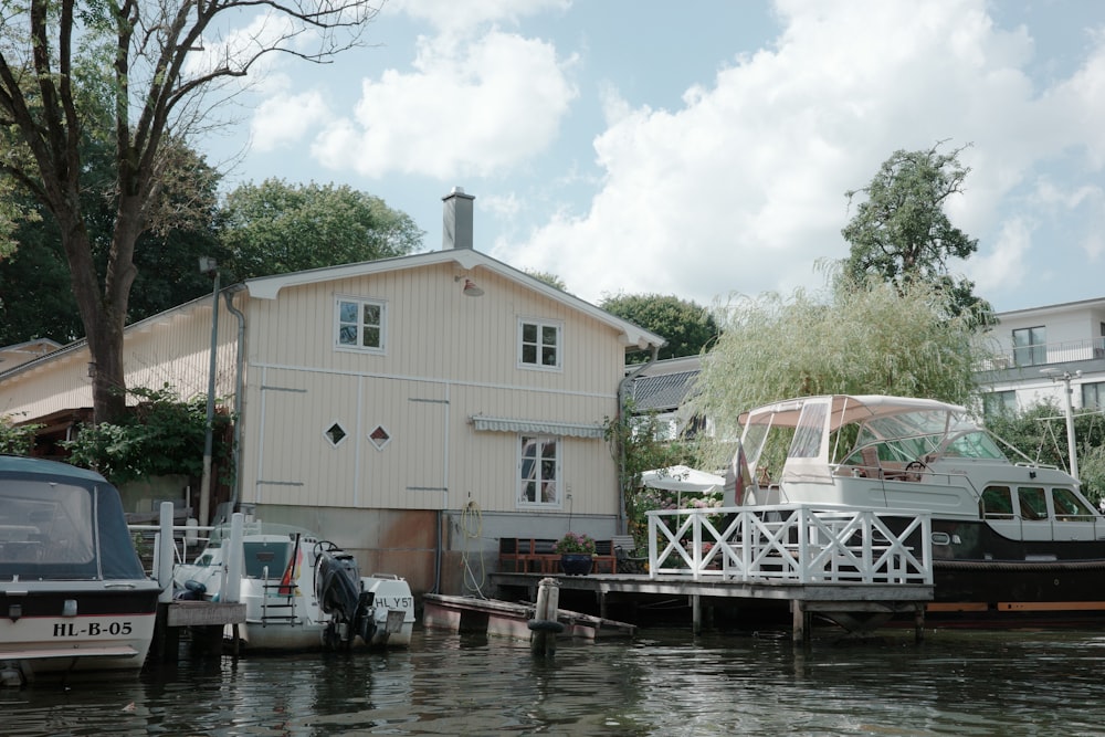 a house on the water with a boat docked in front of it