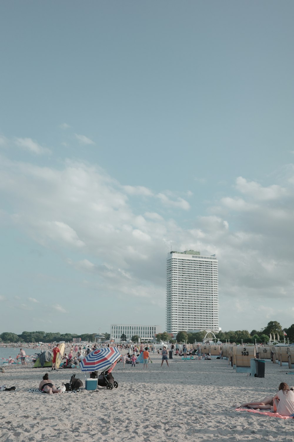 a beach filled with lots of people under a cloudy sky