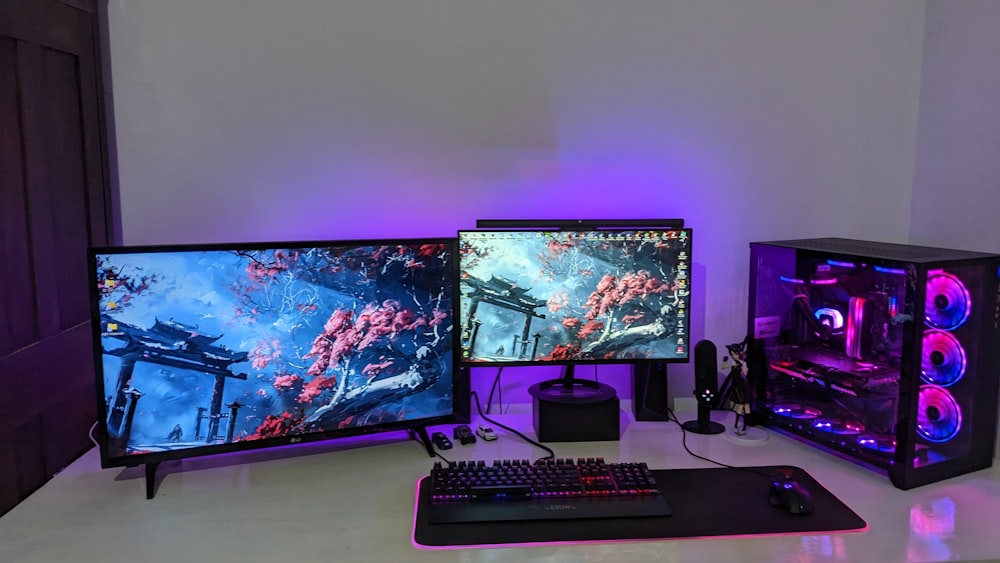 a desk with a keyboard and two monitors