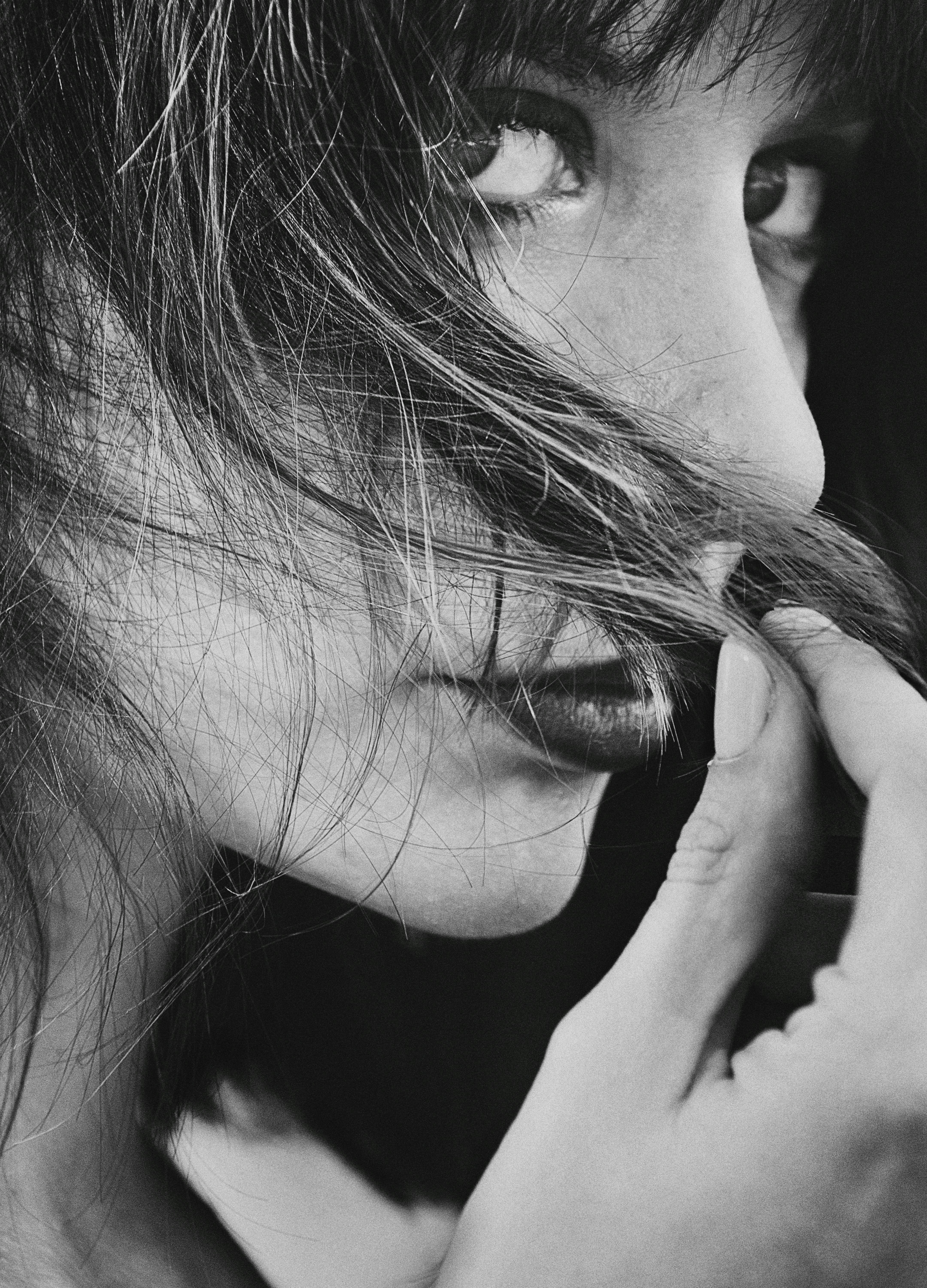 a black and white photo of a woman brushing her hair