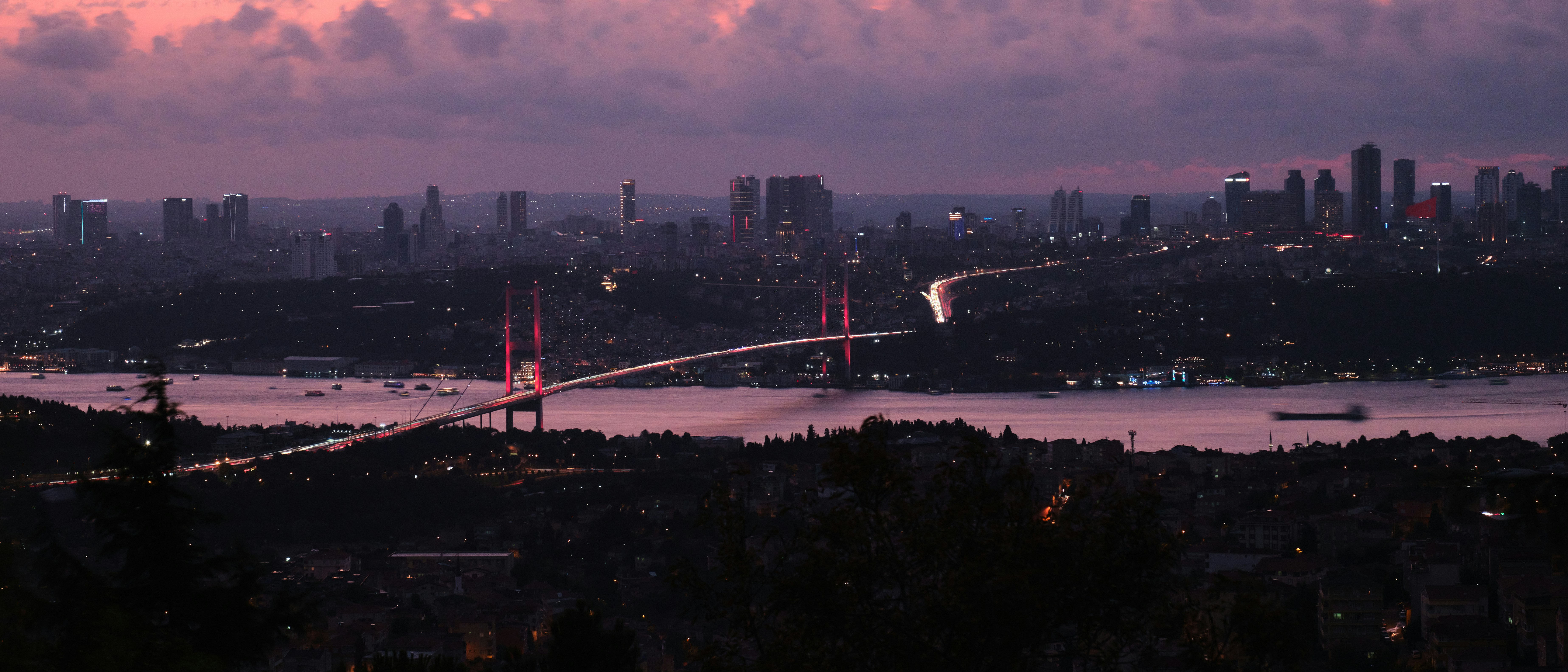 a view of a city and a bridge at dusk