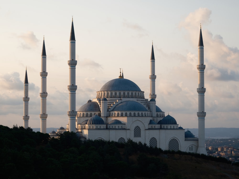 a large white building with three spires on top of a hill