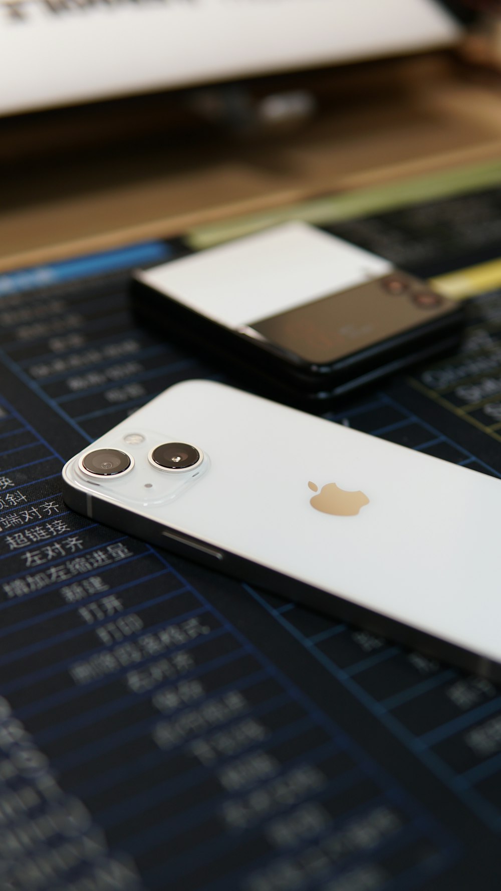 two iphones sitting on top of a table next to each other
