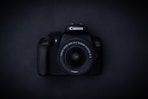 a canon camera sitting on a black surface