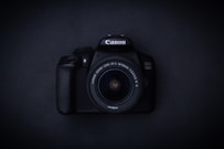 a canon camera sitting on a black surface