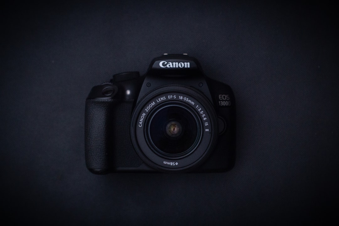 a canon camera sitting on a black surface,