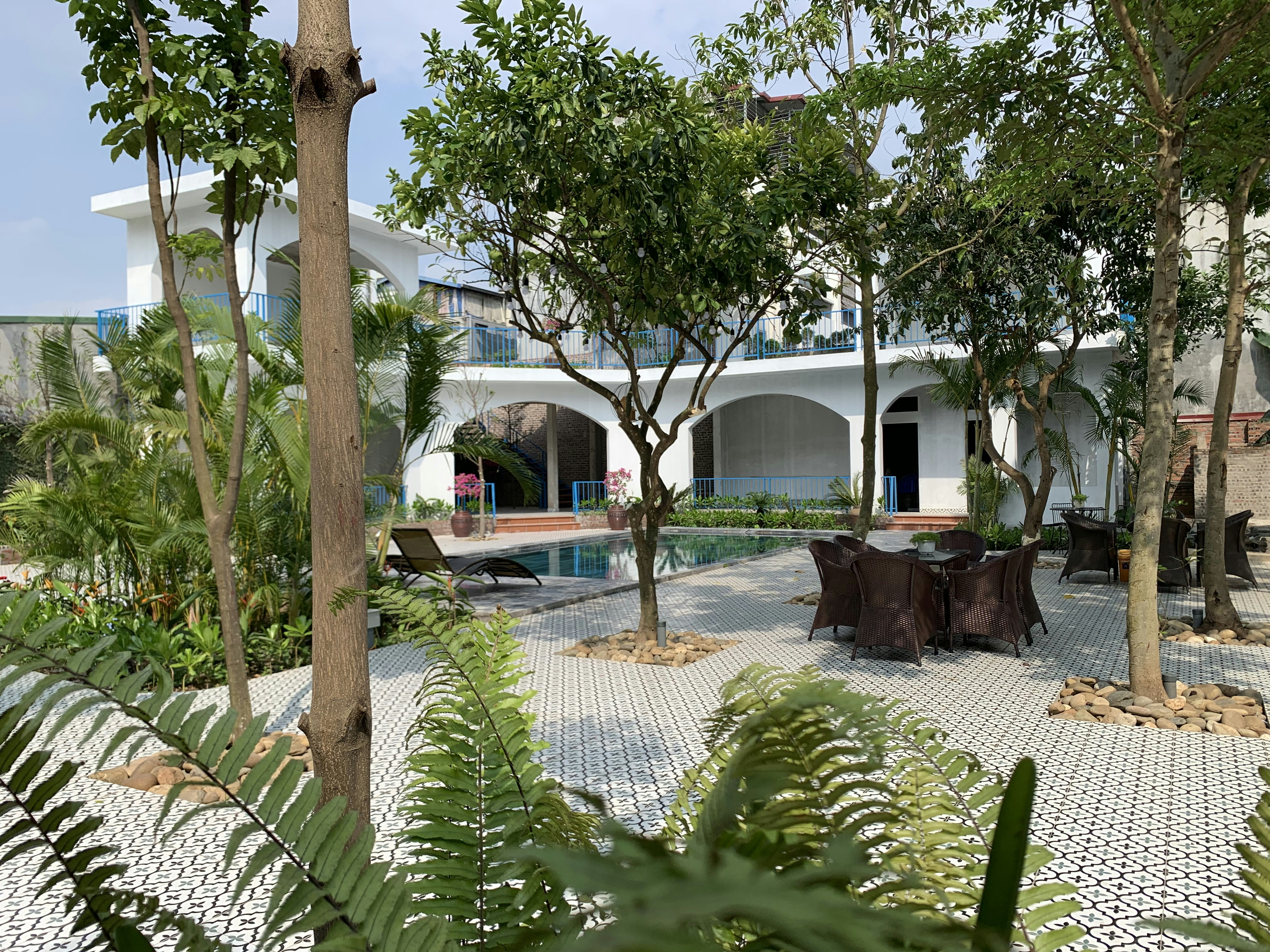 a courtyard with tables and chairs surrounded by trees