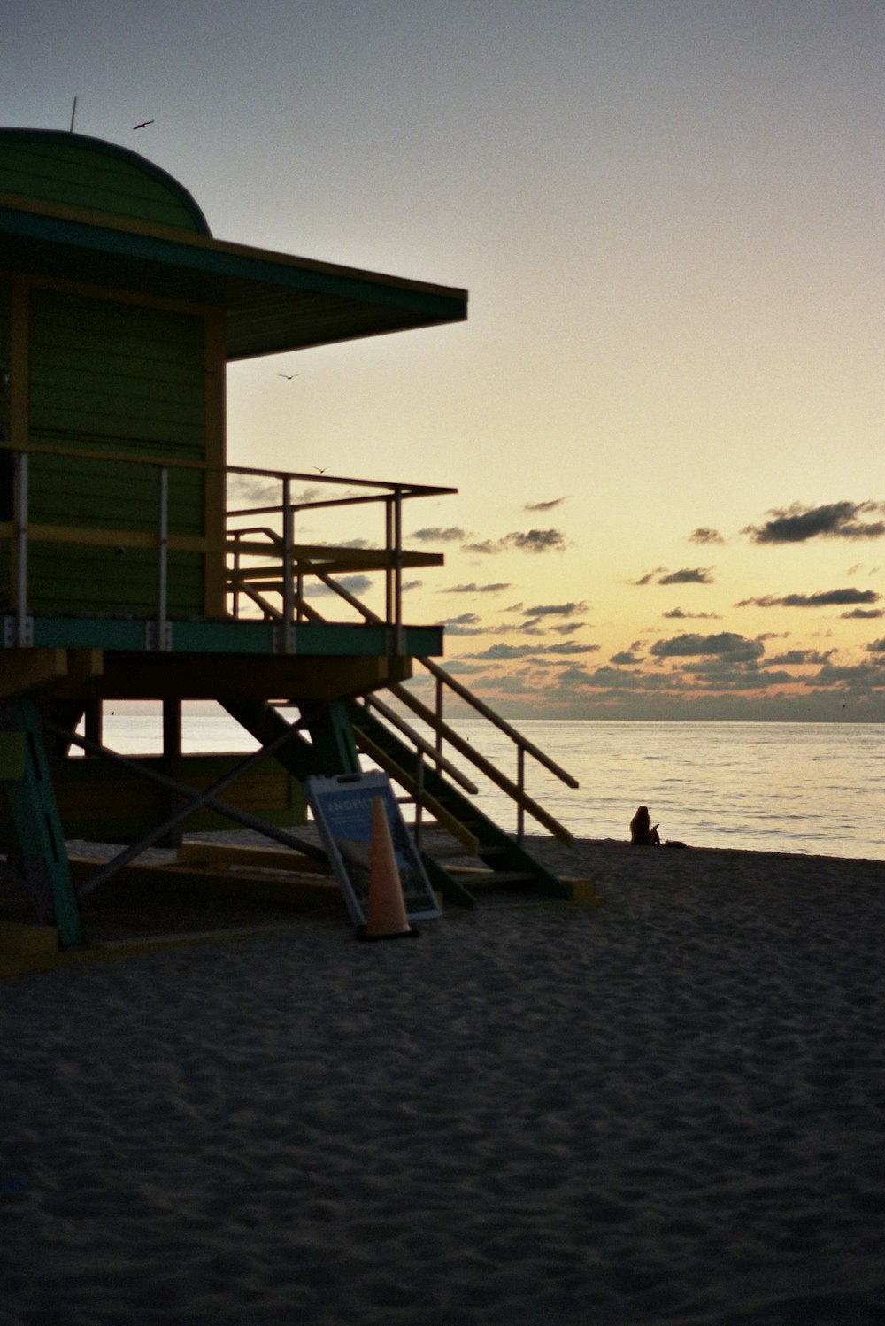 a lifeguard tower sitting on top of a sandy beach