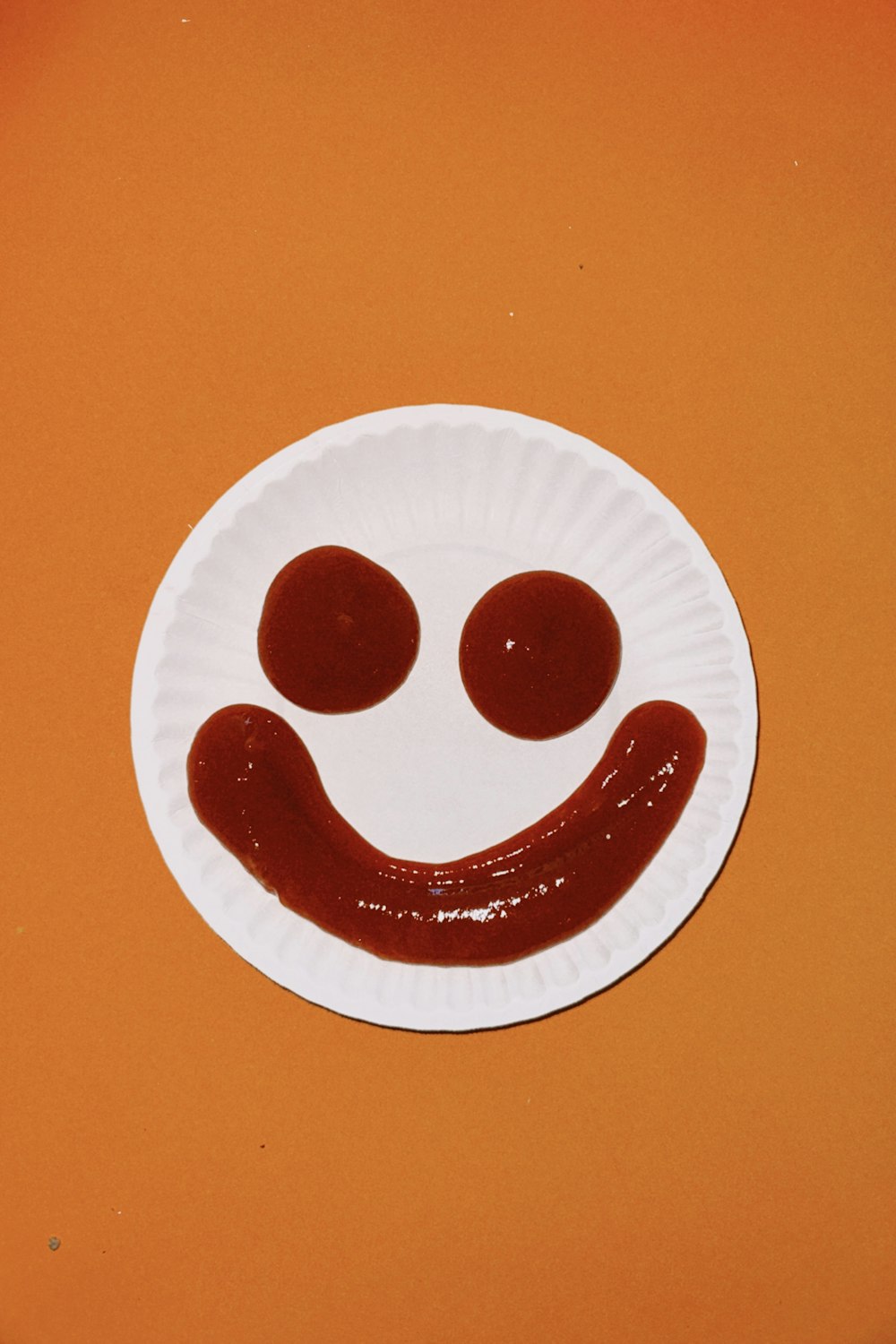 um prato de papel com um rosto sorridente desenhado nele