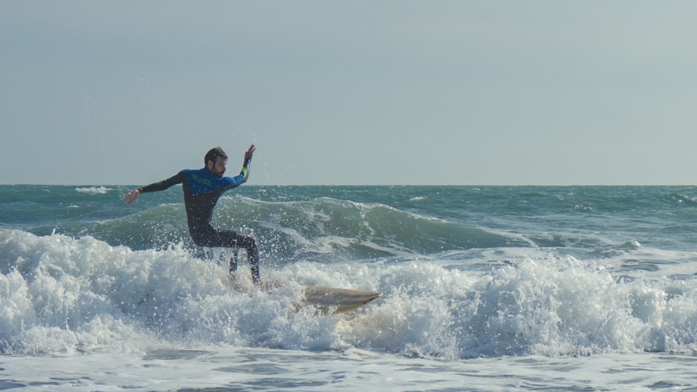 a man riding a wave on top of a surfboard