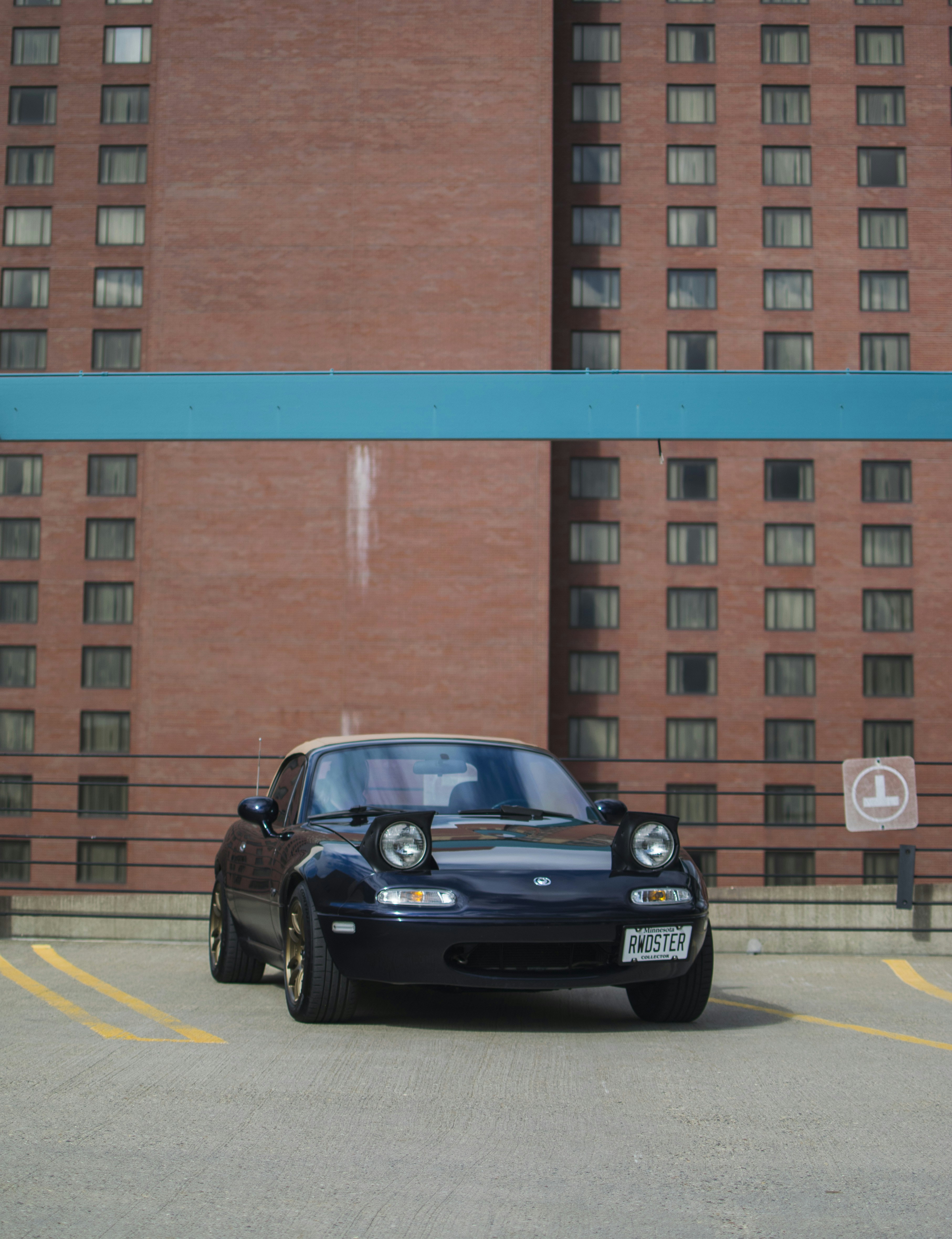 A black car parked in front of a tall building photo – Free Car Image ...