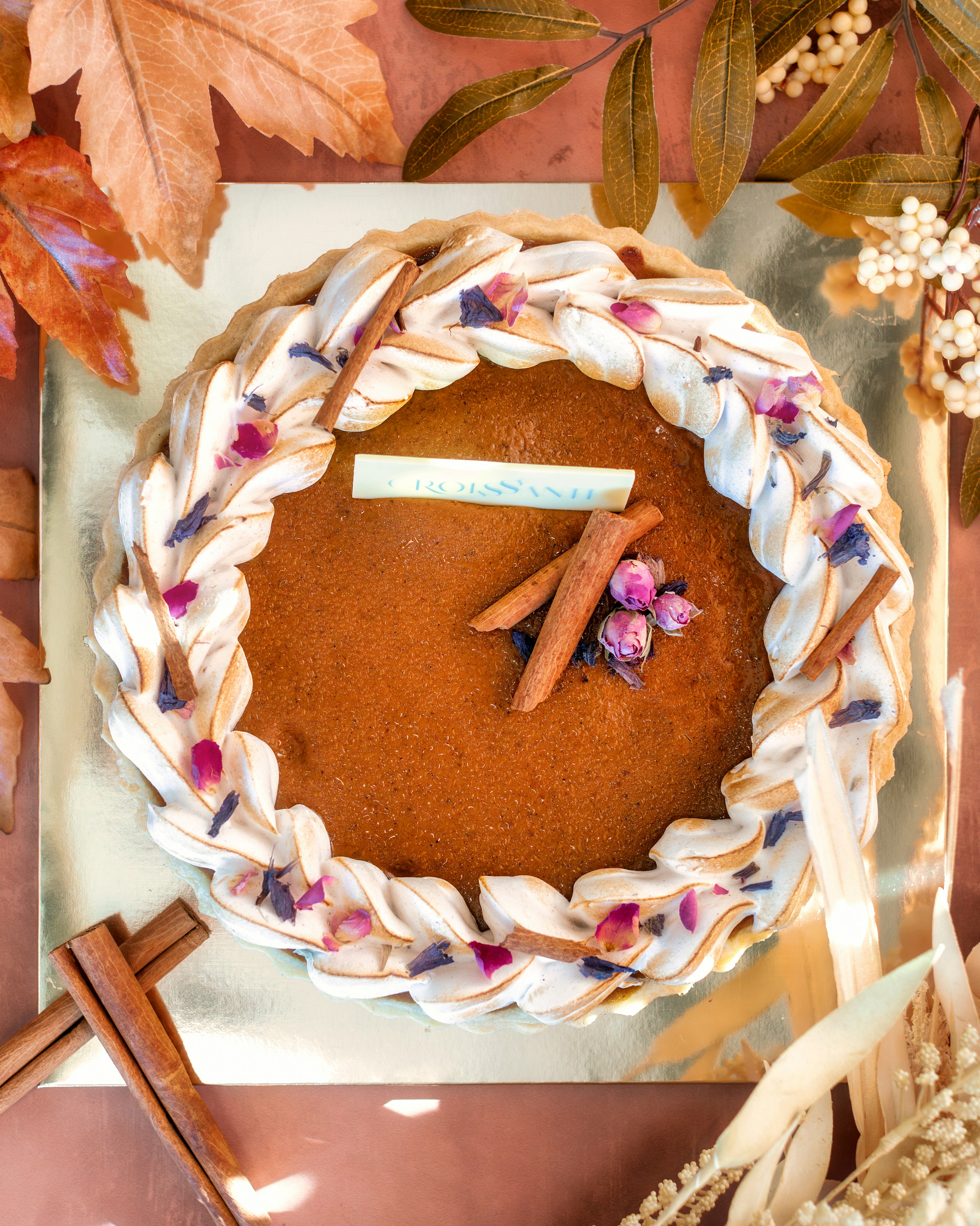 a cake decorated with flowers and leaves on a table