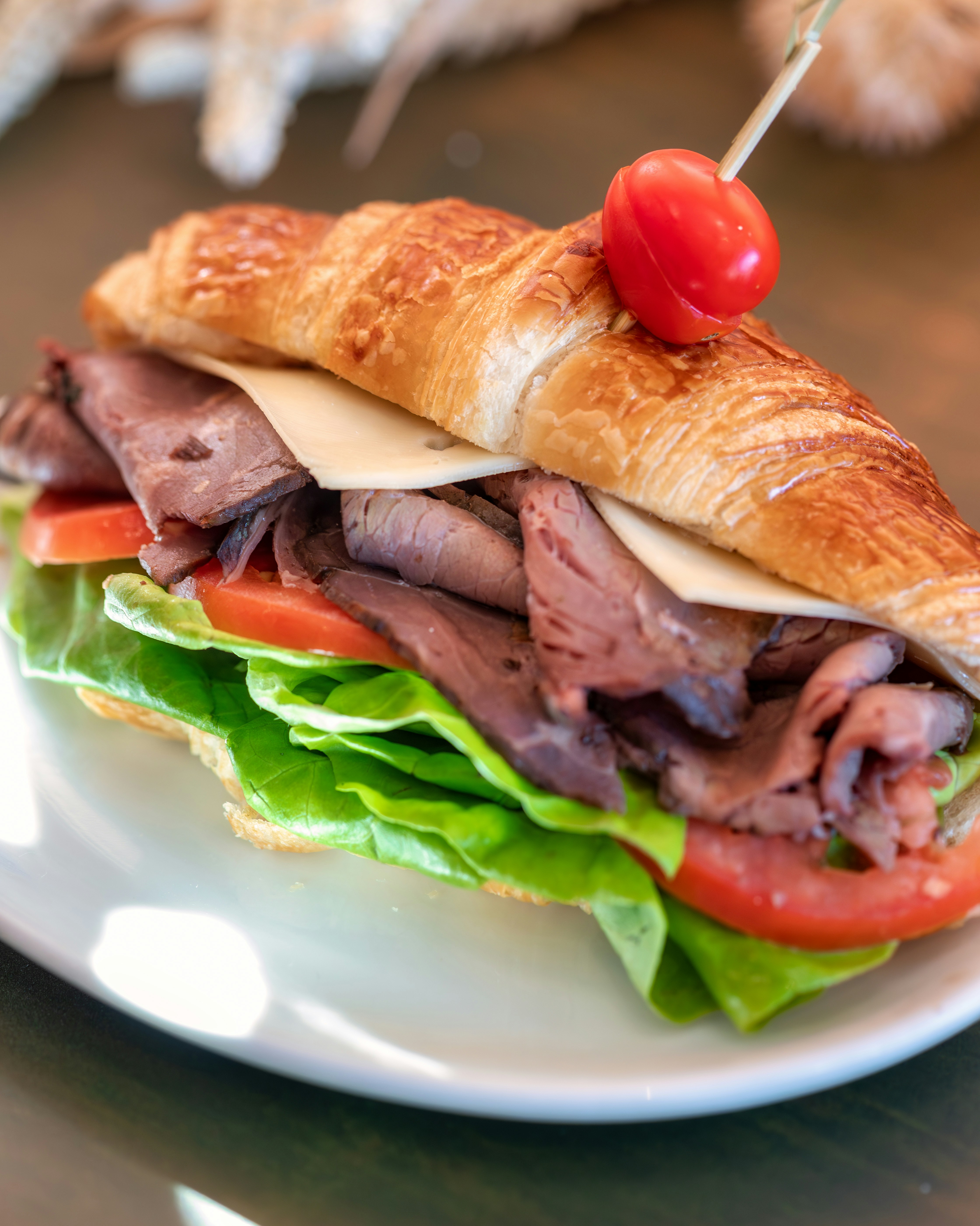 ein Sandwich mit Fleisch, Käse, Tomaten und Salat