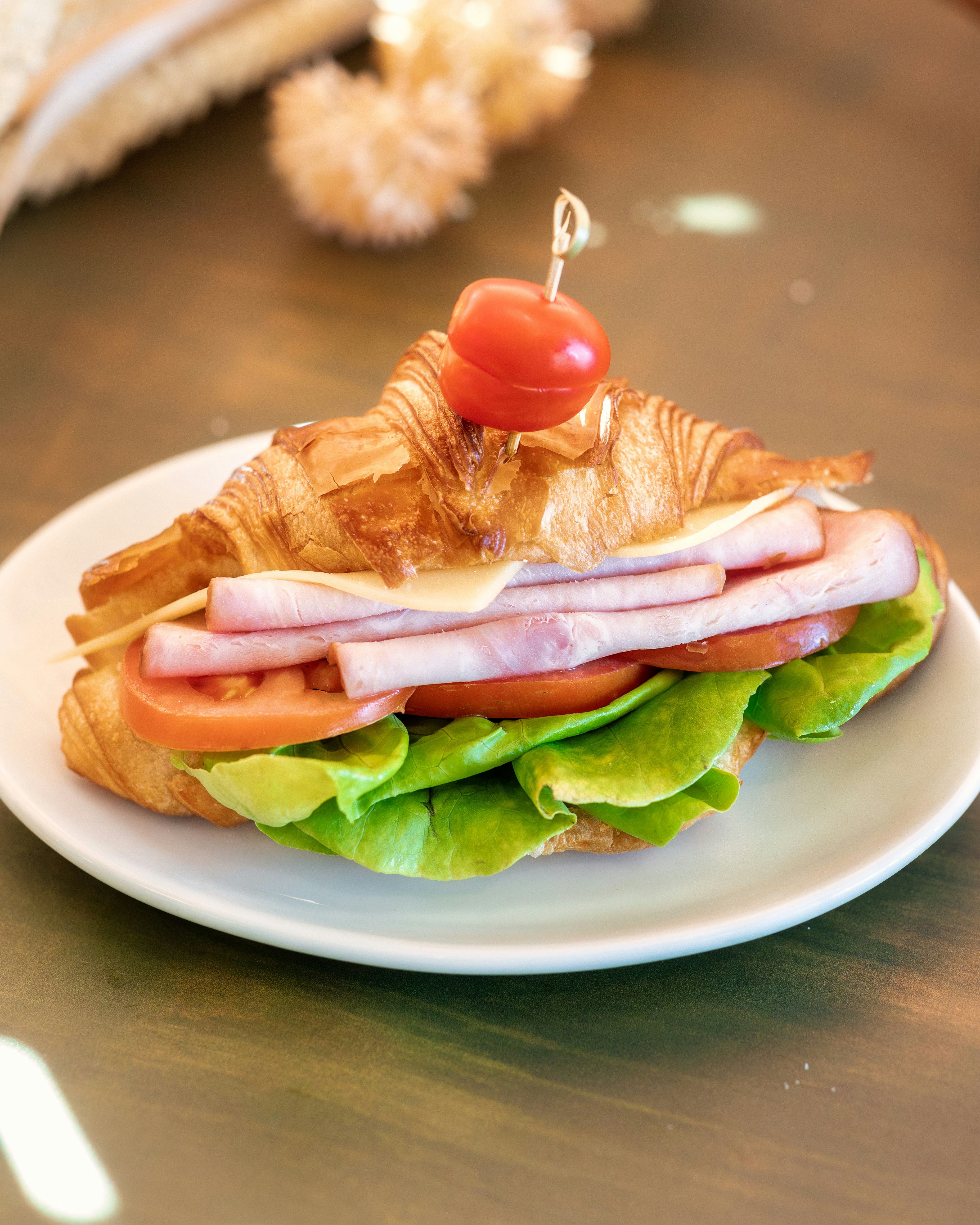 ein weißer Teller mit einem Sandwich auf einem Tisch