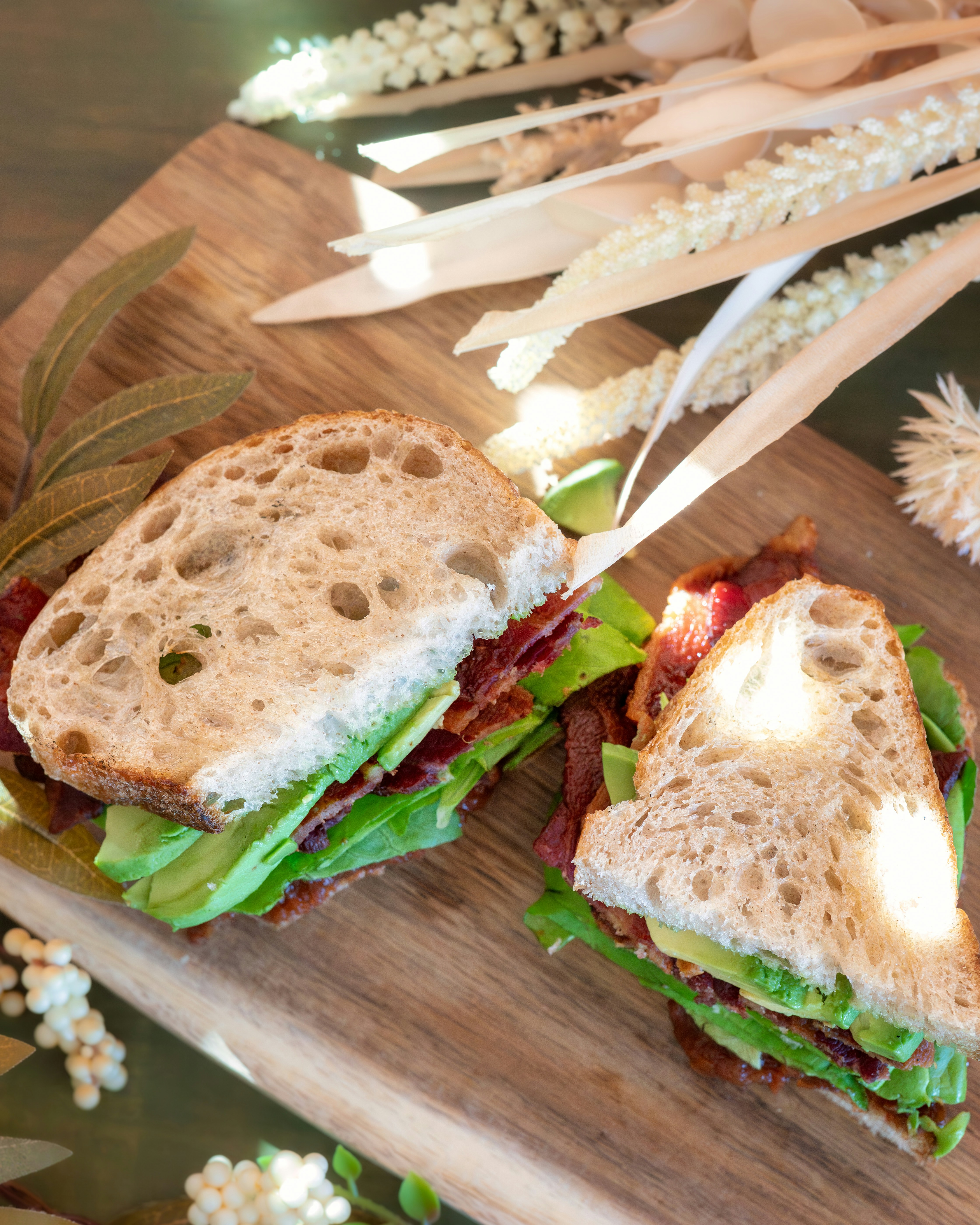 ein halbiertes Sandwich, das auf einem hölzernen Schneidebrett sitzt