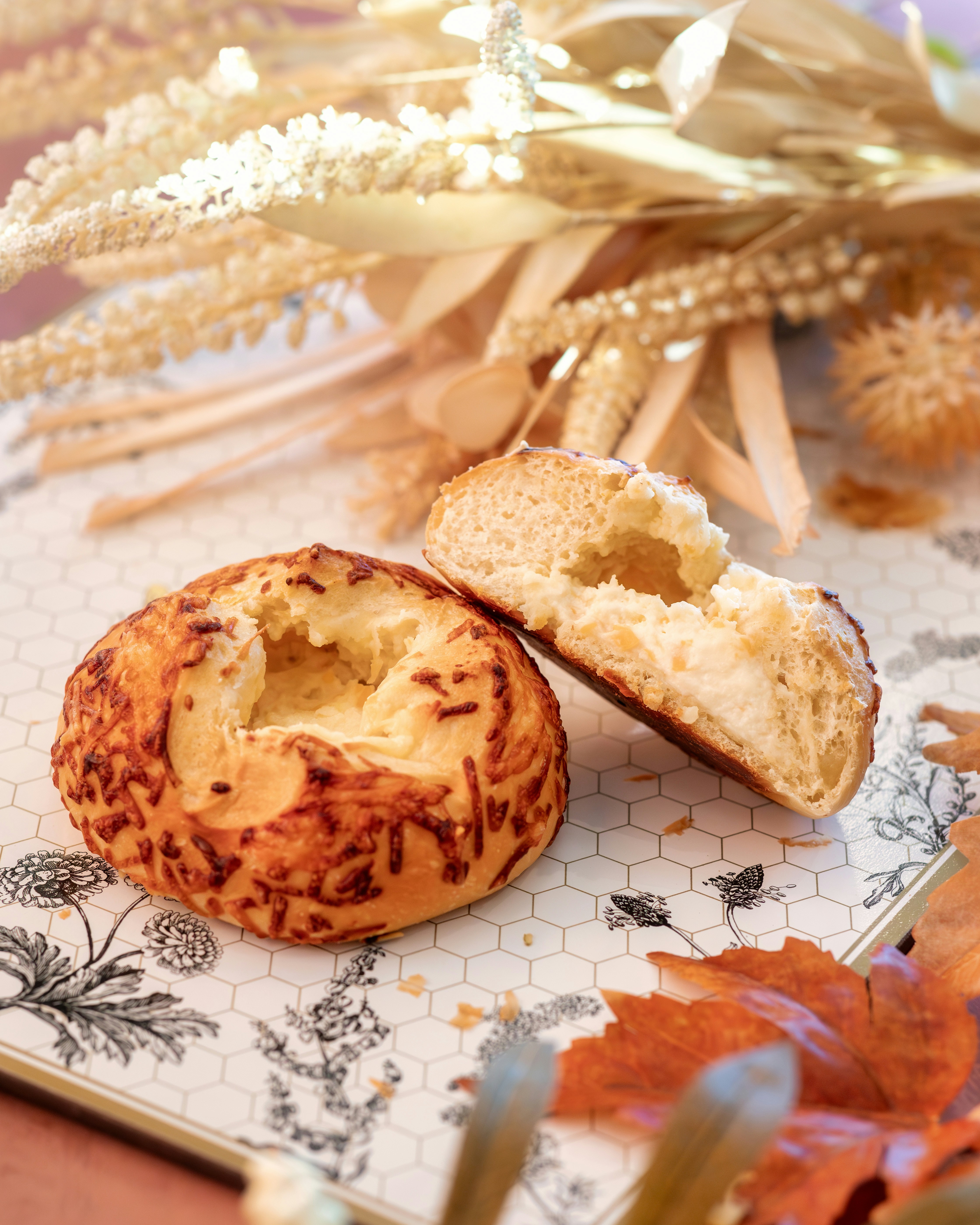 Two cheese-crusted pastries on a patterned serving tray.