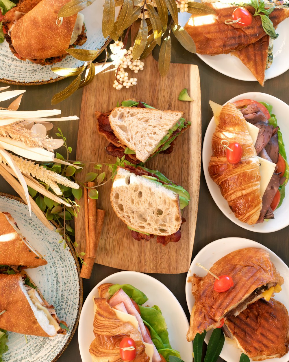 a table topped with plates of sandwiches and croissants