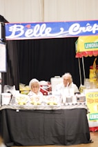 Outdoor event setup with lecrepetin food stall and happy customers enjoying crepes.