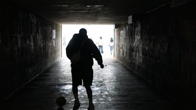 A dramatic shot of a footballer walking through the tunnel before his first match with a new team