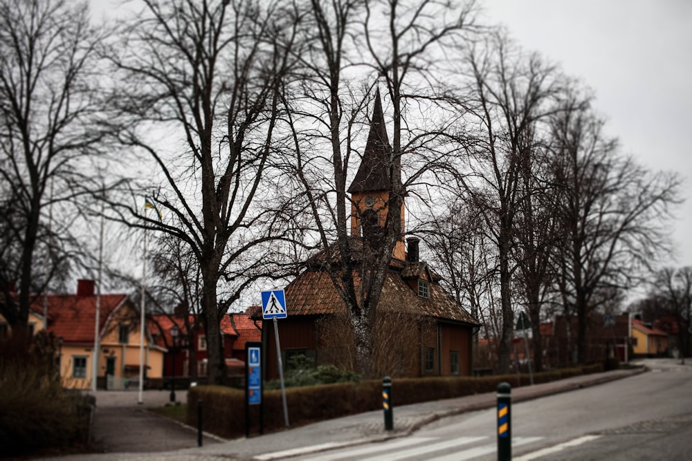 a small church with a steeple on a street corner