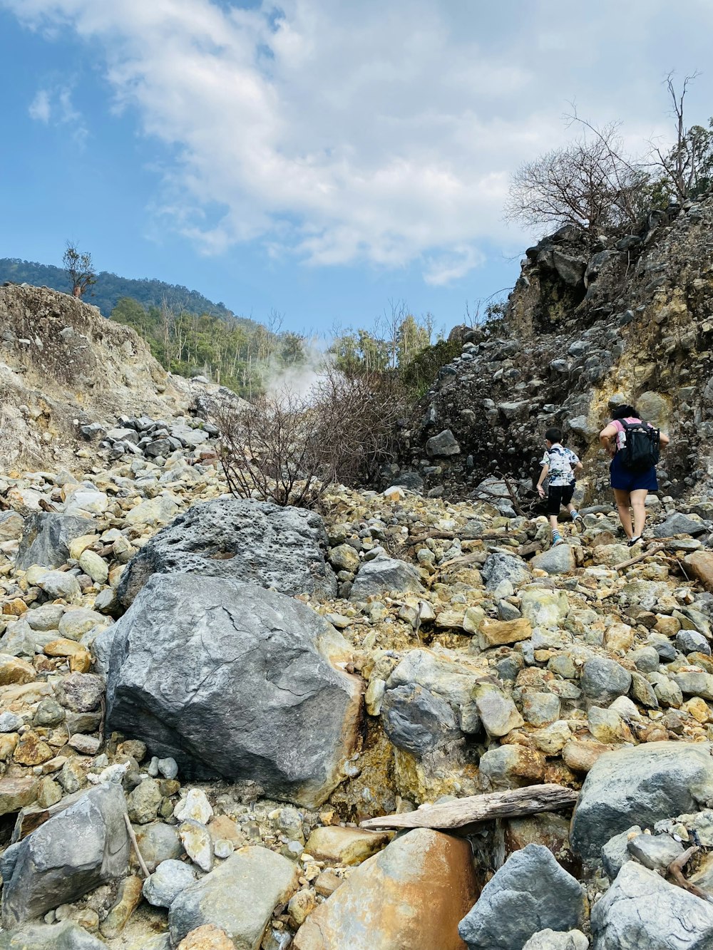 a couple of people that are walking on some rocks