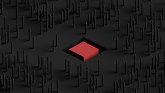 A minimalist 3D scene featuring numerous thin black pillars arranged in a grid-like pattern with a prominent red cube in the center.