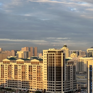 A cityscape covered by a transparent dome with sunshine filtering through.