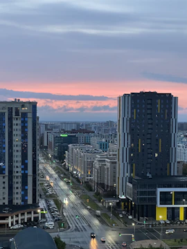 Clean, modern cityscape at dusk with reflective glass buildings and purple-toned lighting conveying a premium agency vibe.