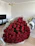Close-up of a vibrant artificial rose bouquet in a cozy living room setting.
