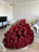 Close-up of a vibrant artificial rose bouquet in a cozy living room setting.