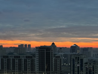 A panoramic view of Riyadh's skyline at dusk, showcasing its modern skyscrapers and vibrant city lights.
