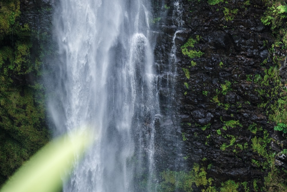 Un homme debout devant une cascade