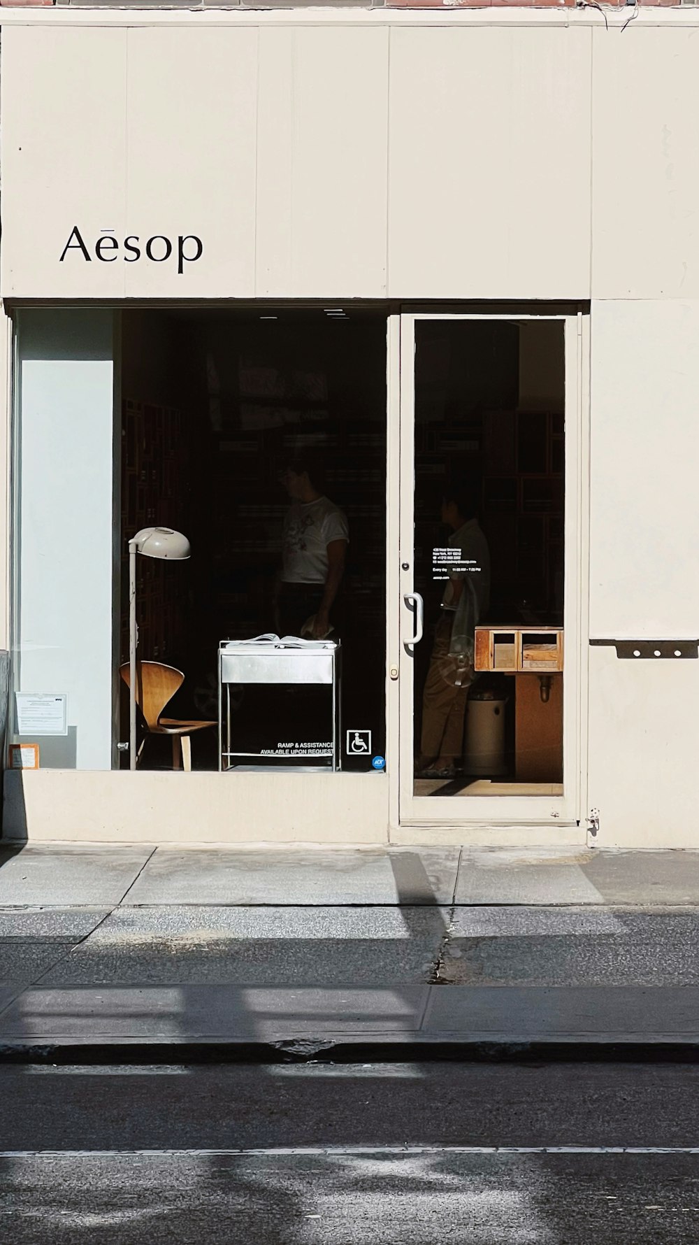 a man walking past a store front on a city street