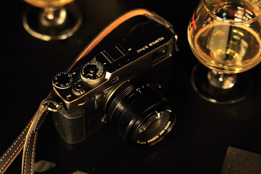 a camera sitting on a table next to a glass of wine