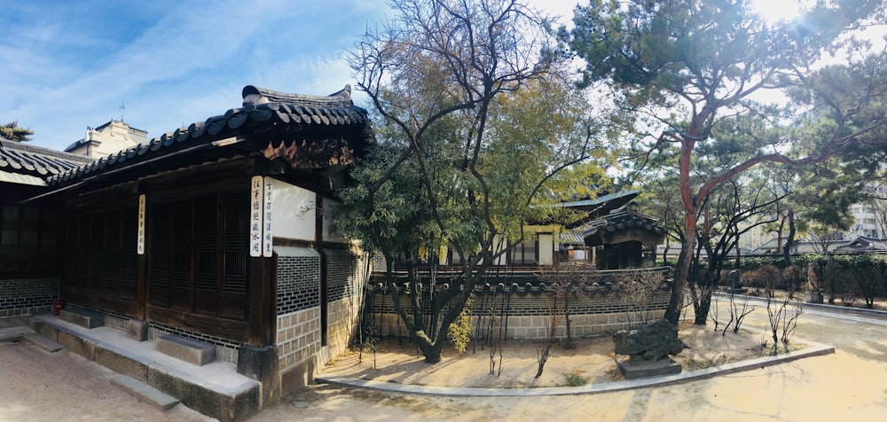 a building with a fence and trees in front of it