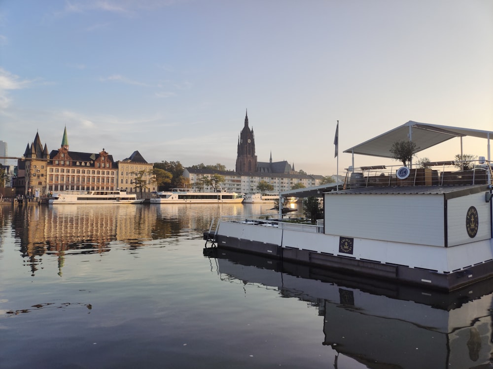 ein Hausboot, das auf einem Fluss vor einer Stadt schwimmt