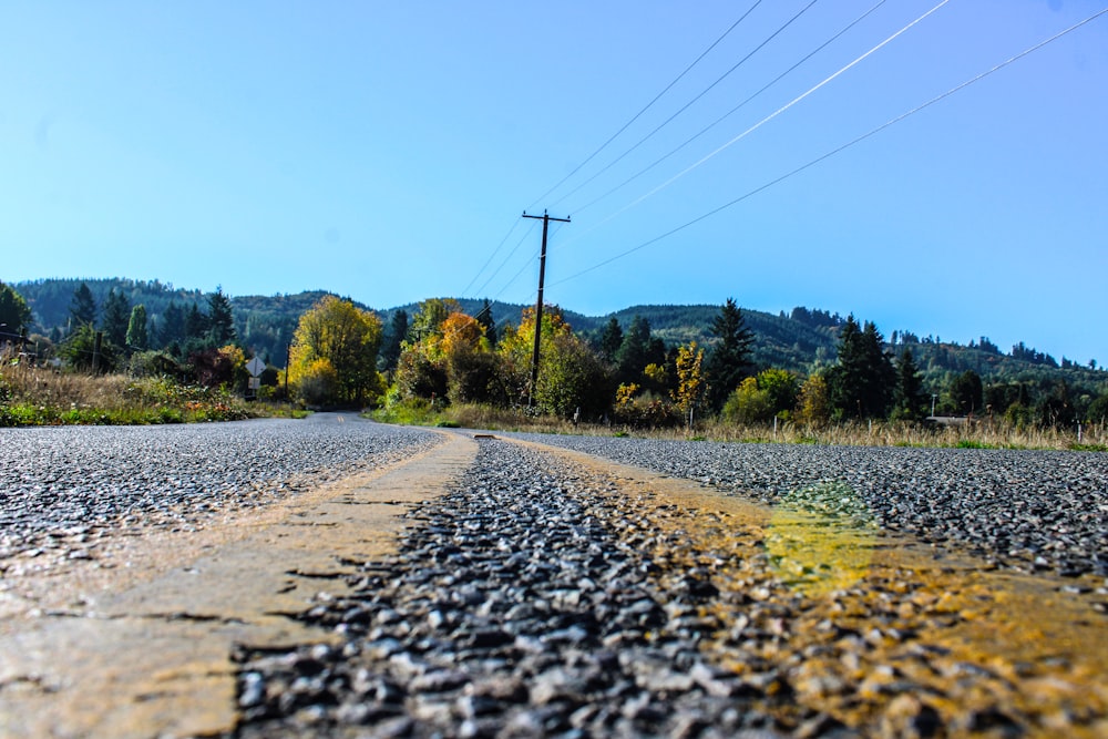 a gravel road with trees in the background